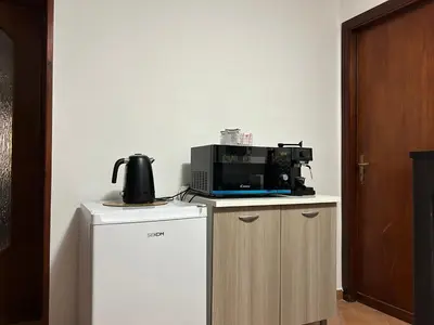 a microwave sitting on top of a refrigerator at DM house in Palermo