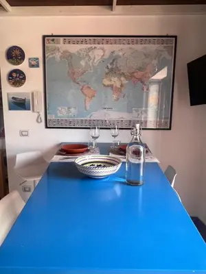a blue table with wine glasses and a map on the wall at Terrazza Rosa Bianca in Palermo