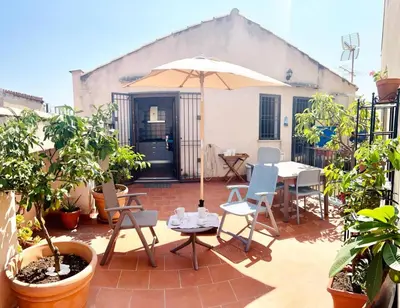 a patio with a table and chairs and an umbrella at Terrazza Rosa Bianca in Palermo