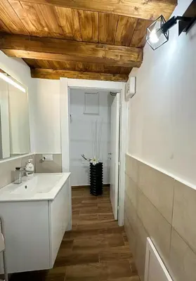 a bathroom with a white sink and a wooden ceiling at Mafone Home in Palermo