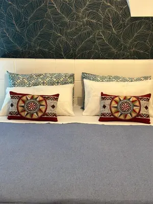 a bedroom with a bed with pillows and a wall at A Casuzza di Gio in Palermo