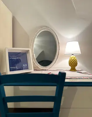 a mirror and a lamp on a table with a chair at A Casuzza di Gio in Palermo