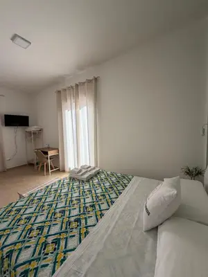 a bedroom with a bed and a table and a television at B&B Le Venere Rooms in Castellammare del Golfo