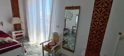 a bathroom with a mirror and a chair in a room at I Sollazzi in Palermo