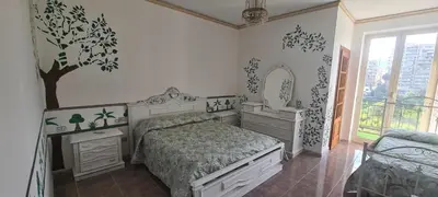 a bedroom with a bed and a tree on the wall at I Sollazzi in Palermo