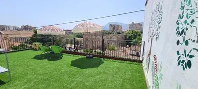 a balcony with green grass and a view of a city at I Sollazzi in Palermo