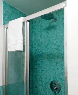 a bathroom with a shower with blue tile at Appartamento Salinas Palermo in Palermo
