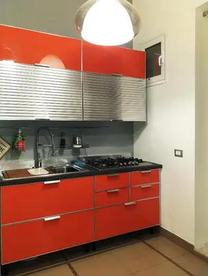 a kitchen with red cabinets and a sink at Appartamento Salinas Palermo in Palermo