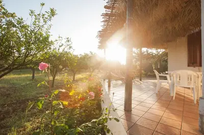 a patio with a table and chairs and the sun at sicilian rustic in Scopello
