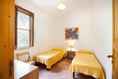 two beds in a room with yellow sheets at sicilian rustic in Scopello
