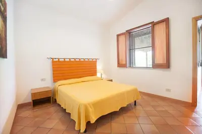a bedroom with a bed with a yellow bedspread at sicilian rustic in Scopello