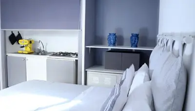 a bedroom with a white bed and a kitchen at Historic Centre - Apartment at Foro Borbonico in Palermo
