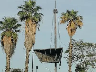 two palm trees with a basket hanging between them at Historic Centre - Apartment at Foro Borbonico in Palermo