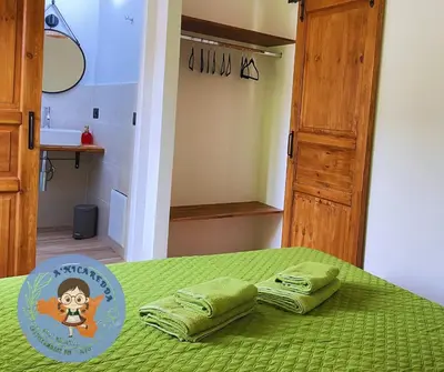 a bedroom with a green bed with two green towels at A'nicaredda (la piccolina) in Castellammare del Golfo