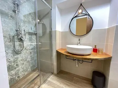 a bathroom with a sink and a shower with a mirror at A'nicaredda (la piccolina) in Castellammare del Golfo