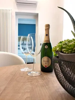 a bottle of champagne and two wine glasses on a table at Al Massimo apartment in Palermo