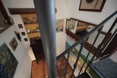 a staircase in a house with paintings on the wall at Room in Villa Galletti Inguaggiato in Bagheria