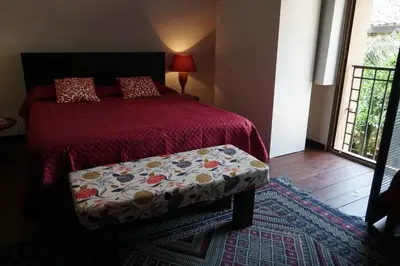 a bedroom with a bed with a red comforter and a bench at Room in Villa Galletti Inguaggiato in Bagheria