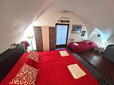 a living room with a red couch and a bed at Room in Villa Galletti Inguaggiato in Bagheria