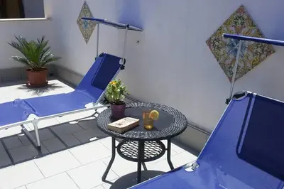 a patio with a table and chairs on a balcony at King's Residence in Balestrate