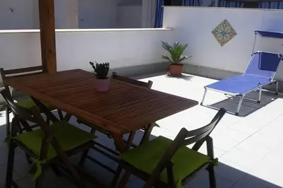 a wooden table and chairs on a patio at King's Residence in Balestrate