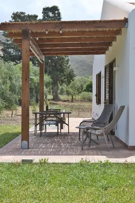 a patio with a table and chairs under a pergola at Villa Memi in Cefalù