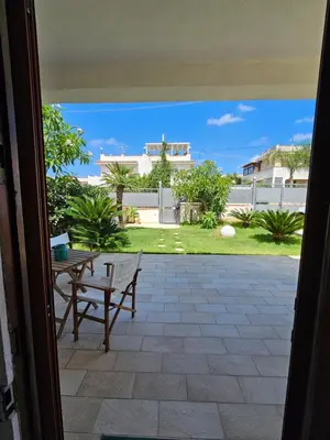 a view of a patio with a table and bench at IsolaHome in Isola delle Femmine