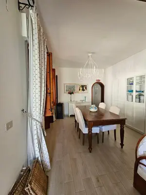 a dining room with a table and chairs and a chandelier at IsolaHome in Isola delle Femmine