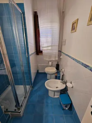 a bathroom with two toilets and a glass shower at IsolaHome in Isola delle Femmine