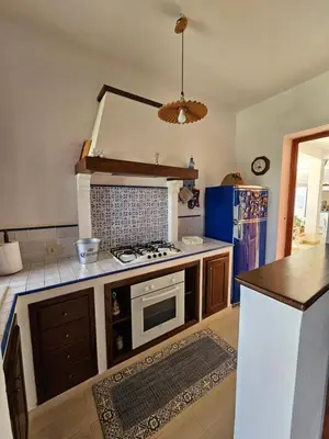 a kitchen with a stove and a counter top at IsolaHome in Isola delle Femmine