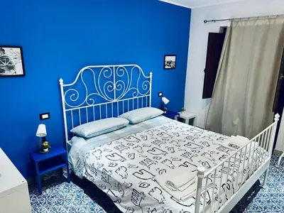 a blue bedroom with a bed with a blue wall at Corleone Home in Corleone