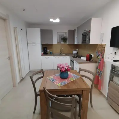 a kitchen with a wooden table with chairs and a table at Futtitinni Home casamia in Palermo