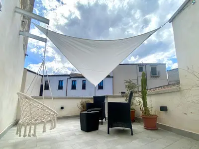a patio with a table and chairs and a net at A casa di Alex in Palermo