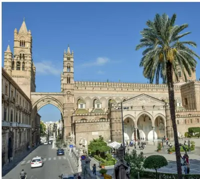 a large building with a palm tree in front of it at City Center Apartment da FeLù in Palermo
