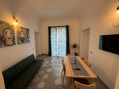 a living room with a couch and a table and a television at City Center Apartment da FeLù in Palermo