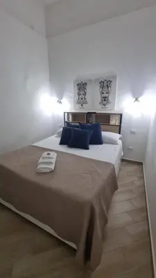 a bedroom with a large bed with blue pillows at Il quaRtetto apartment in Palermo
