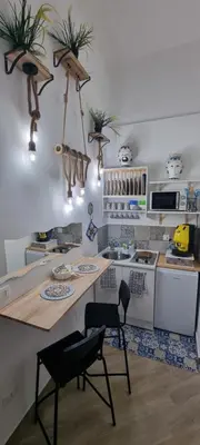 a kitchen with a counter and a table with chairs at Il quaRtetto apartment in Palermo