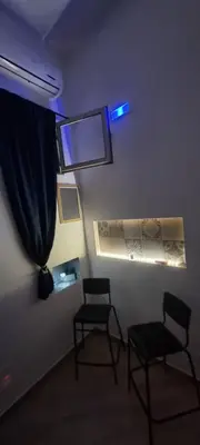 two chairs and a window in a room with purple lights at Il quaRtetto apartment in Palermo