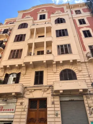 a tall white building with windows and doors at 