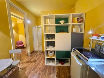 a kitchen with yellow walls and a white shelf at MATTI X 2 in Palermo