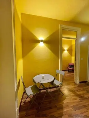 a table and chairs in a room with a yellow wall at MATTI X 2 in Palermo
