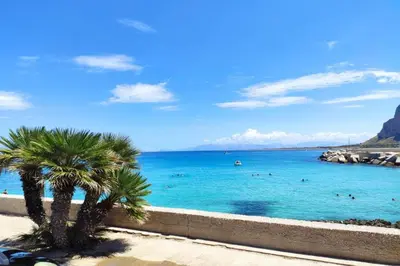 a palm tree sitting next to a body of water at Villa Macari Fantastic Sea View - Happy Rentals in Macari