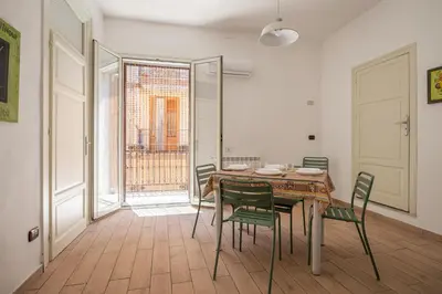 a dining room with a table and green chairs at Casa Ferrito - Porticello in Porticello