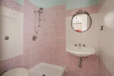 a bathroom with a sink and a toilet and a mirror at Casa Ferrito - Porticello in Porticello