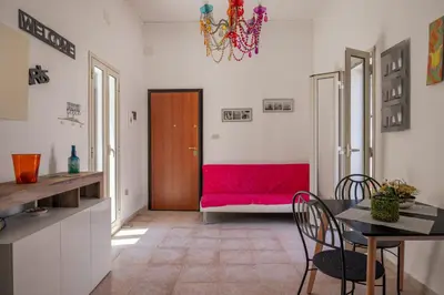 a living room with a red couch and a table at Casa Ferrito - Porticello in Porticello