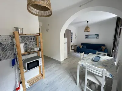 a living room with a table and a blue couch at Tampasiando in Cinisi