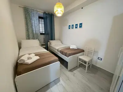 a small room with two beds and a chair at Tampasiando in Cinisi