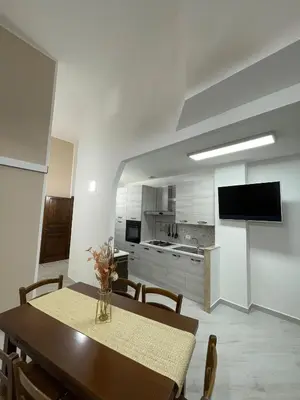 a dining room with a table and a kitchen at Civico 356 in Castellammare del Golfo