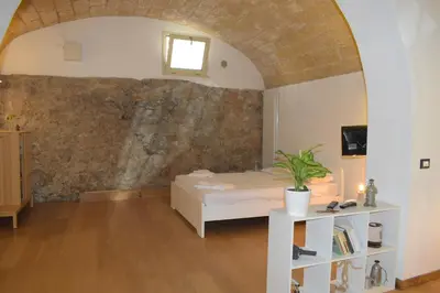 a bedroom with a bed and a brick wall at Casa Selinunte in Palermo
