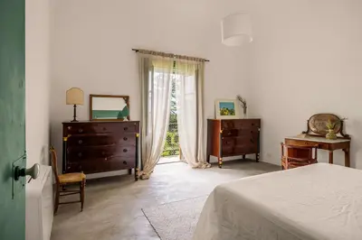 a bedroom with a bed and a dresser and a window at Villa surrounded by Nature overlooking the Sea - Cefalù in Lascari